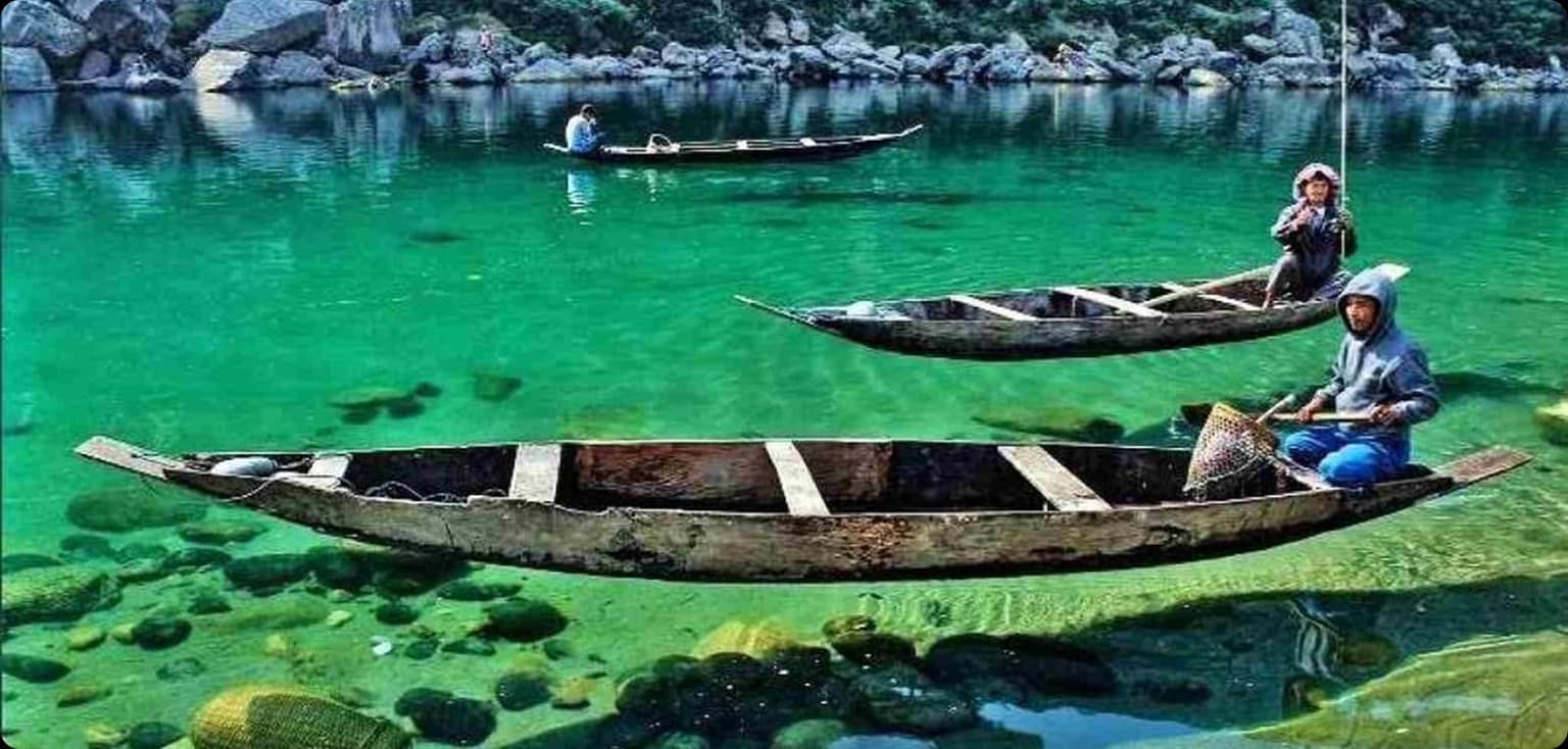 Clear water of the Umngot river at Dawki with boats