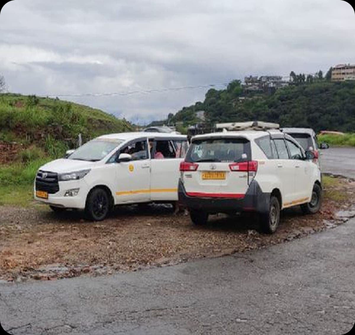 Two Explore Roots vehicles parked on a hill road during a trip